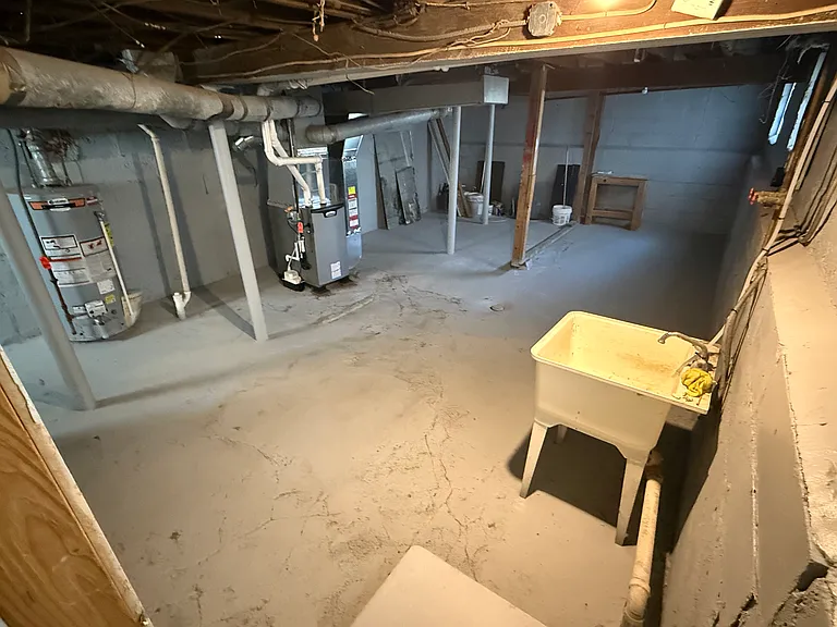 Sizable basement. Three glass block windows. Utility sink. Brand new washer and dryer installed 2025 (not shown here). Brand new hot water tank and furnace (2025). Concrete basement floor resurfaced and painted, walls painted (2025). Dry basement.