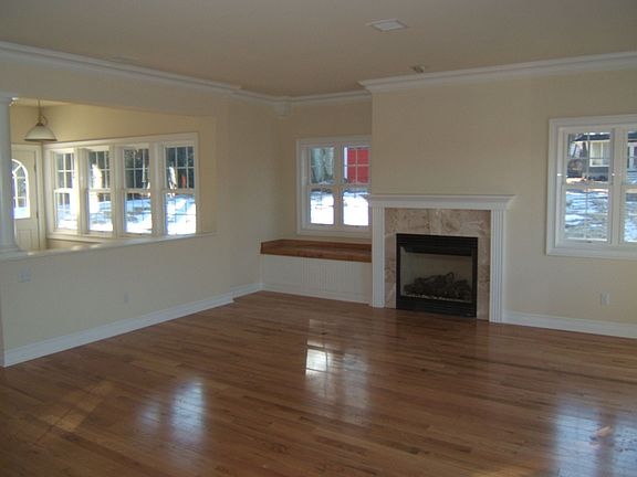 Living Rm w/window seat & marble surround gas fireplace, wood flooring