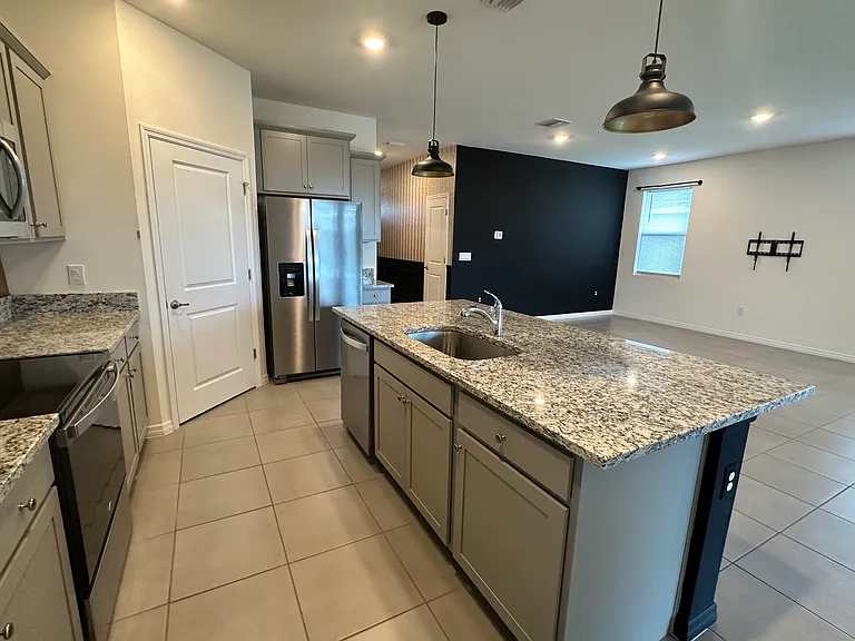 Kitchen with modern appliances and granite countertops.