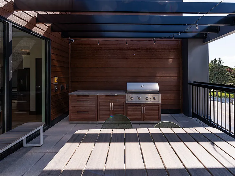 A covered patio with seating and a Community Gas Grill for outdoor cooking.