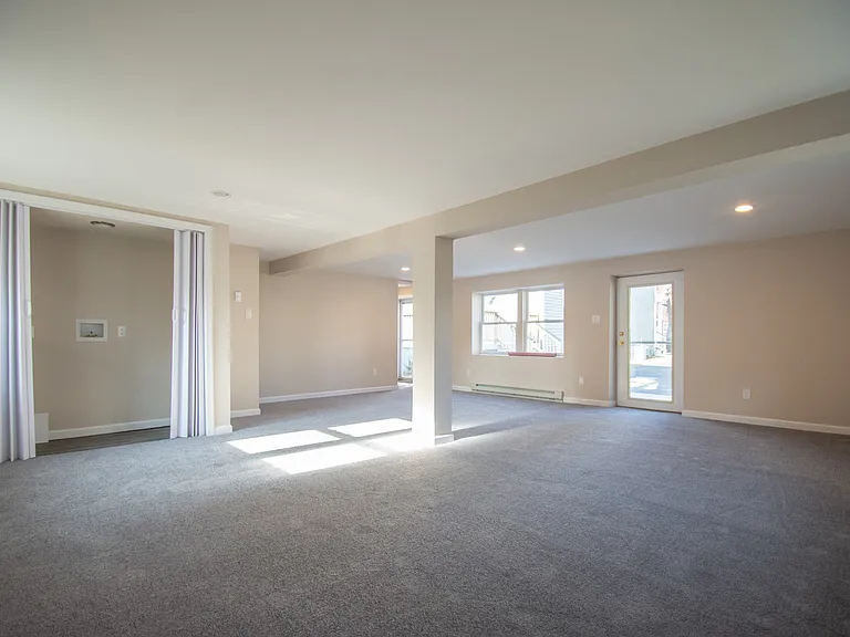 Ground level, open concept living/office/recreation room with laundry closet.