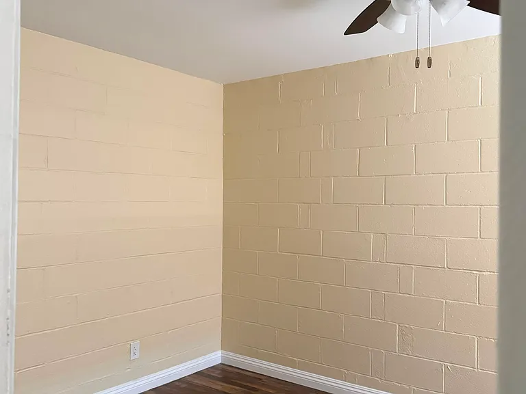 The bedroom has a new ceiling fan, hardwood flooring, and built-in storage space.