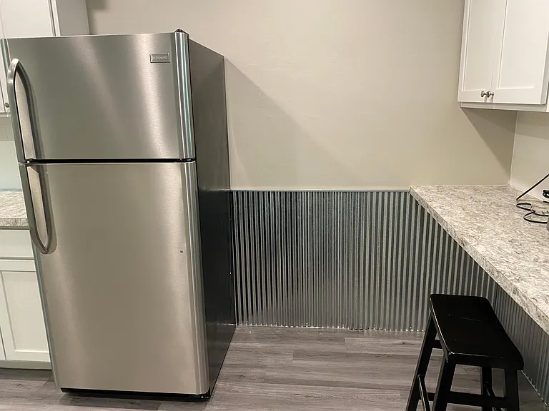 Small barstool seating area in kitchen with corrugated steel