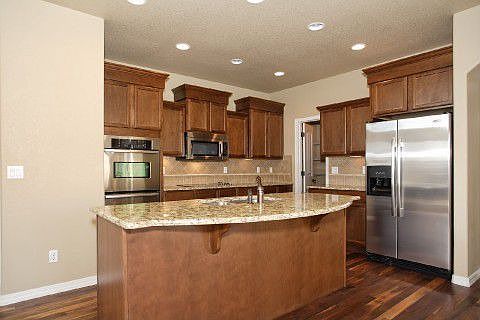 Gourmet kitchen has slab granite counters and island