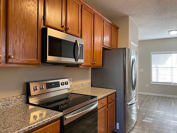 Kitchen with LVP flooring, granite, stainless appliances, updated light fixtures.