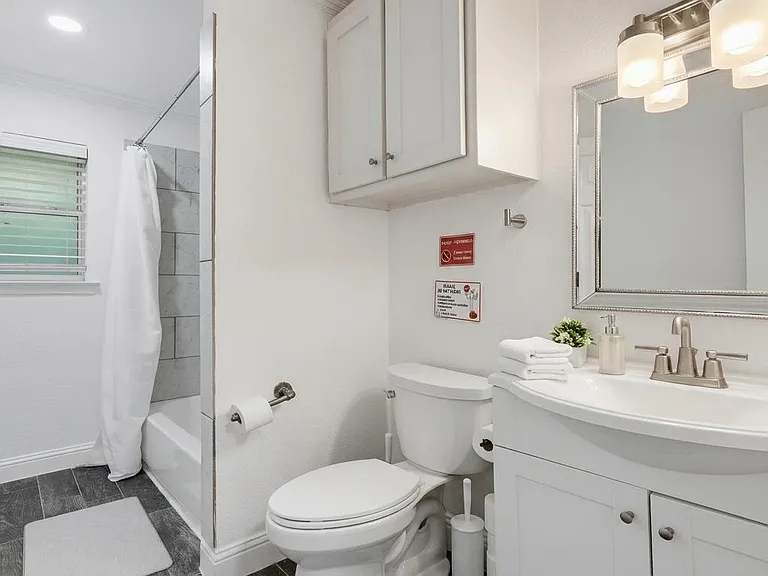 Clean full bath with tub/shower combo, oversized vanity storage, and a window for ventilation and natural light.