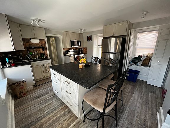 Many drawers for storage in the kitchen island with a quarry stone island and counter top
