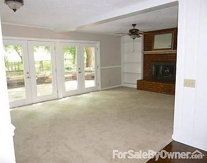 Living Room with wood burning fireplace
						:
						entertainment center, book cases, 2 double closets, French doors to shaded patio