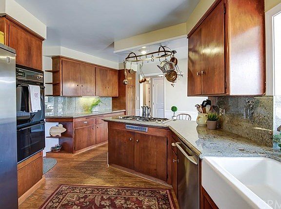 Spacious eat-in kitchen with granite counters and backsplash, apron sink, double oven, Jenn Air cooktop and custom bay windows that make the space light and bright.