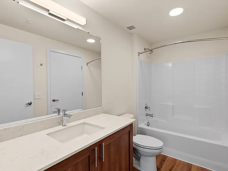 Contemporary bathroom with sleek finishes and full tub-shower combo. Contemporary bathroom with sleek finishes and full tub-shower combo.