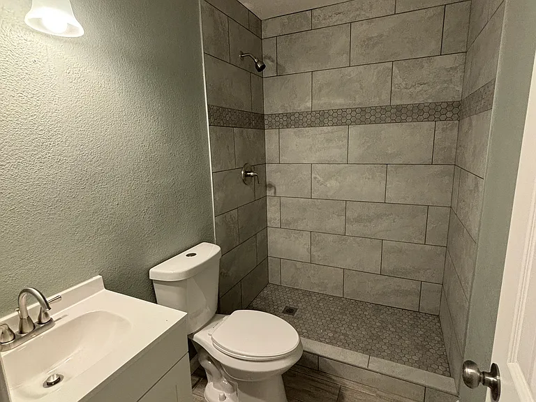 Beautiful custom tile shower, toilet, vanity and sink.
