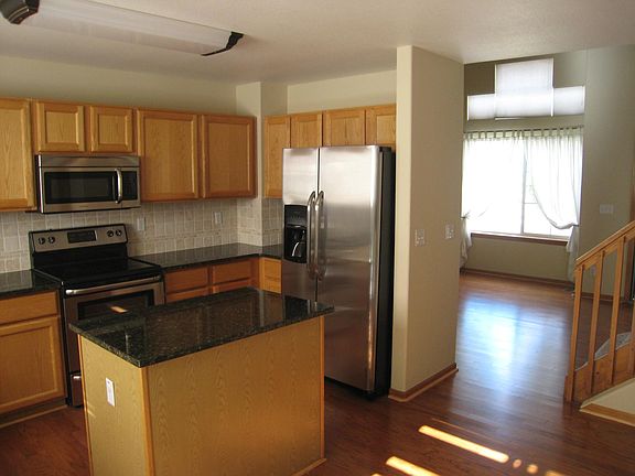 Kitchen with island, granite counter tops, electric stovetop.