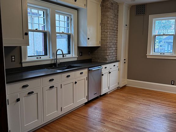 Kitchen with custom cabinets, soft-close drawers, and hidden compartments. Walls are now a soft yellow.
