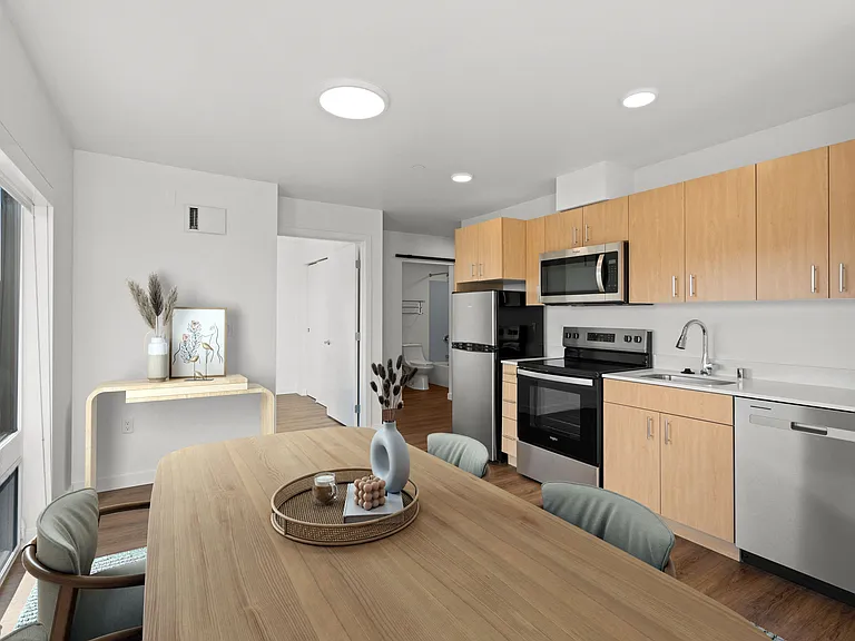 This open kitchen and dining room features a wooden table, creating an inviting and functional space for meals and gatherings.