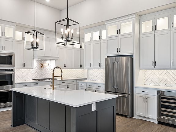 The kitchen of the Hefner has a gorgeous wood cabinetry and tile backsplash.