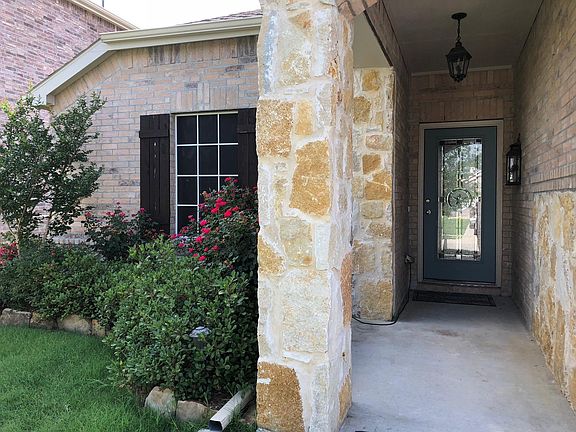 front entrance of the house with plants and roses