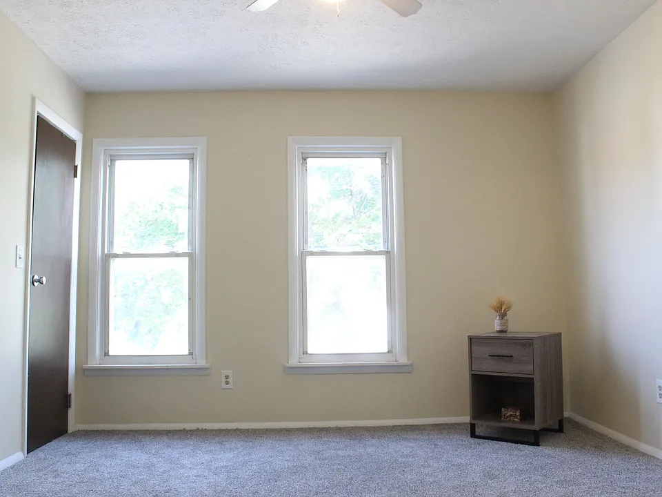 The main bedroom with a closet on the left hand side door. It has brand new carpeting and a ceiling fan.