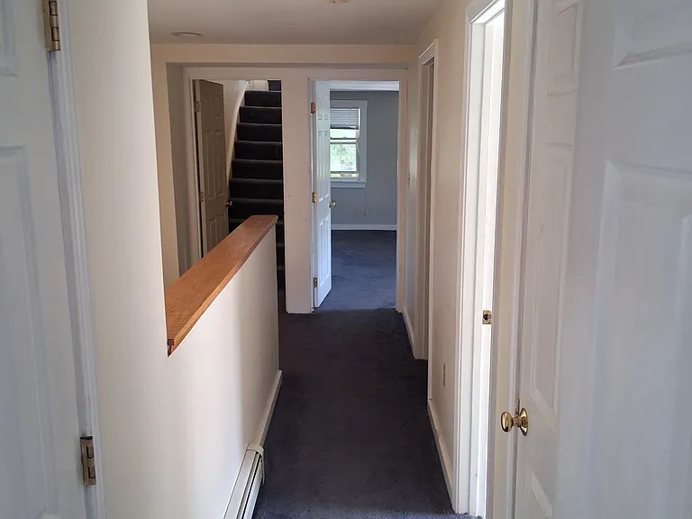 Upstairs hall with bedrooms at either end. Bonus closets on the right and left. Full bath and laundry room are off this hall on the right.