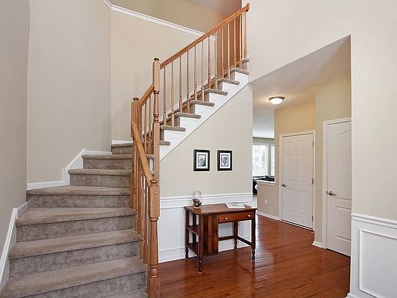 Impressive 2 Story Foyer Graced With Hardwood Floors