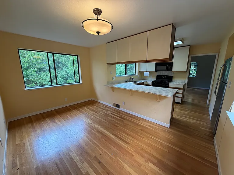 Dining area & kitchen, opens to living room beyond. Door to the attached enclosed garage to the left (not shown in the photo)