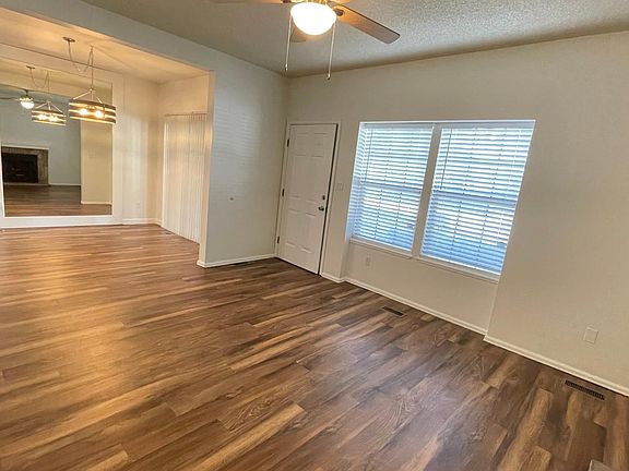 View from living room into dining area with large accent mirror, and contemporary flooring