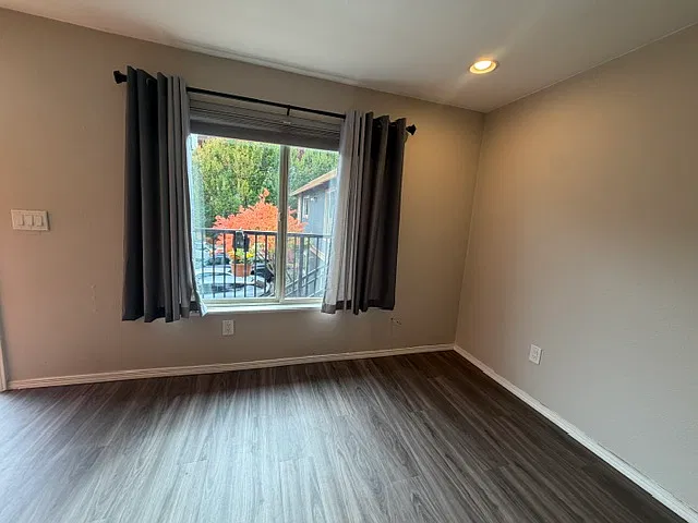 Living room with view thru window. Window features up/down shades and curtains.