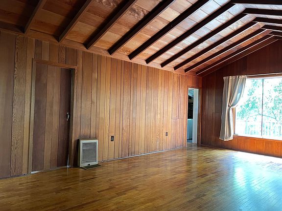 Great room with large picture window looking toward the back deck and yard.