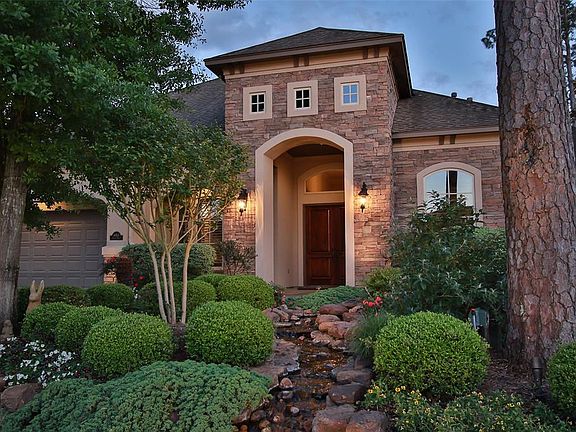 BABBLING BROOK WATER FEATURE - As you approach the house you hear the sounds of the water feature in the front of the home. The well manicured landscaping and accent lighting make this house glow at night.