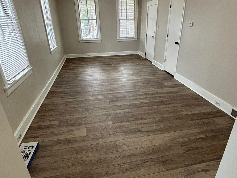 Living room. Door closes to window is front entrance to apartment.
