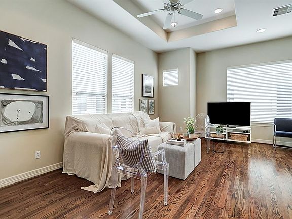 This generous 18X10 living room features hardwoods, tray ceiling, and large windows that overlook the community. Faux wood privacy blinds throughout!