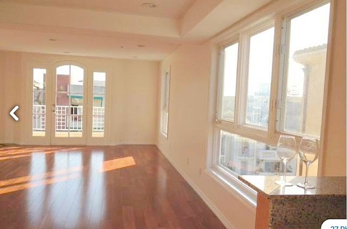 high ceiling living room with balcony and city view