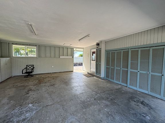 semi enclosed carport showing entrance to kitchen. With a walk way to side of home leading to downstairs bonus room. More closets for extra storage and washer/dryer hook up