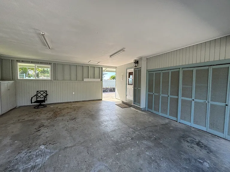 semi enclosed carport showing entrance to kitchen. With a walk way to side of home leading to downstairs bonus room. More closets for extra storage and washer/dryer hook up