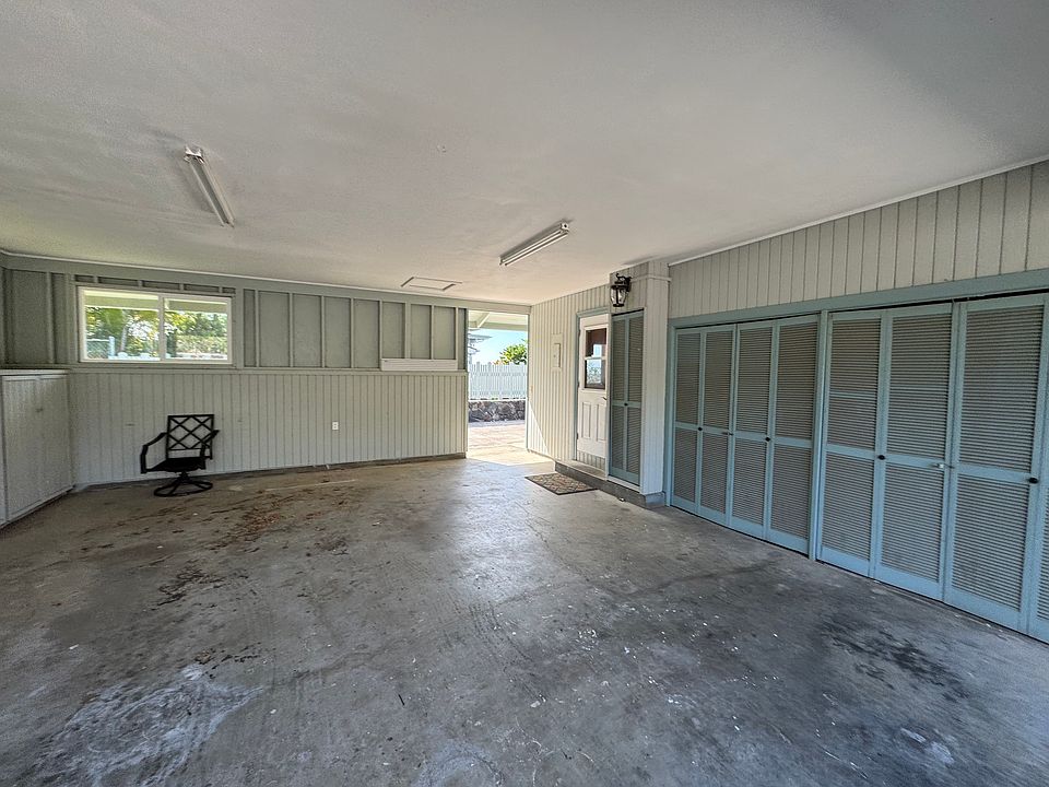 semi enclosed carport showing entrance to kitchen. With a walk way to side of home leading to downstairs bonus room. More closets for extra storage and washer/dryer hook up
