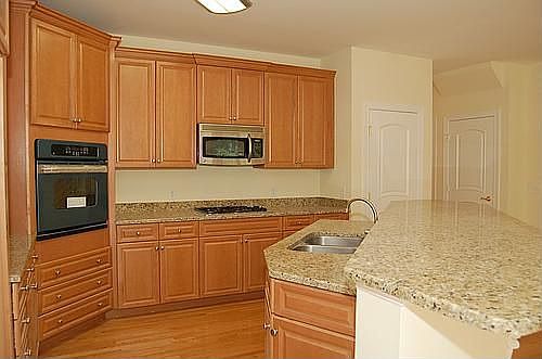 Gormet kitchen with gas cooktop, built in oven, & granite countertops.