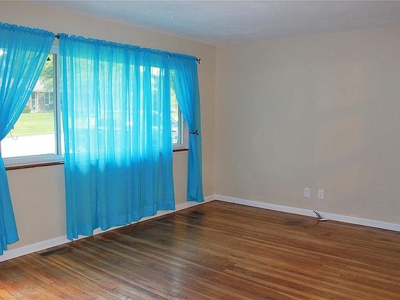 Family room features a large picture window and beautiful hardwood floors.
