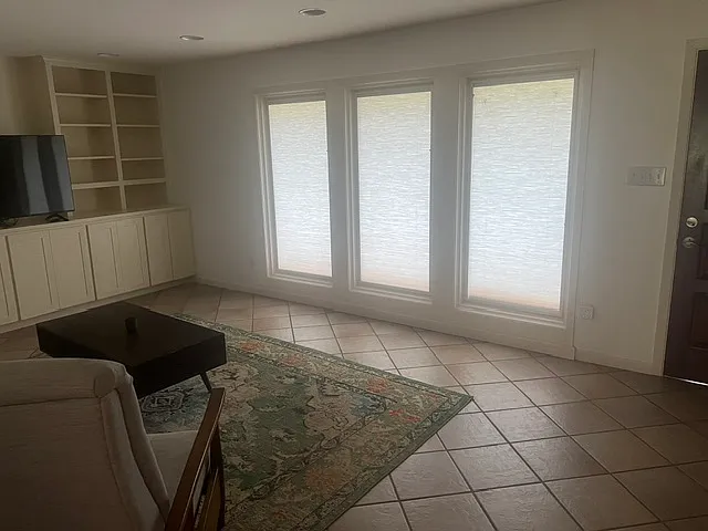 Living room with large windows facing the street. Pella windows have built in shades.
