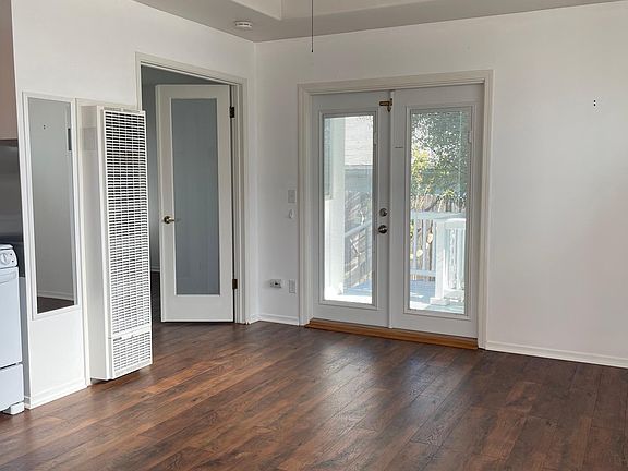 Living room and kitchenette space. Beautiful new flooring. Overhead fan, coved ceiling and dimmed lighting.
