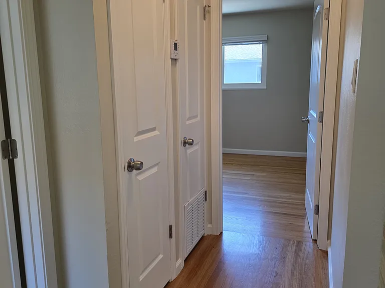 Hallway leading to the larger bedroom. All interior doors are new.