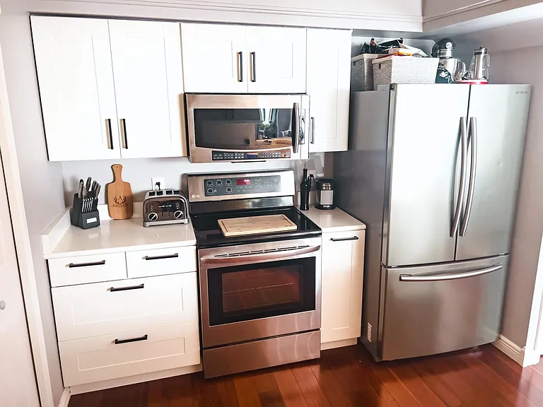 White soft close kitchen cabinets, updated hardware and stainless steel appliances.