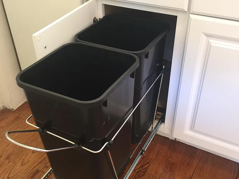 Space saving and hidden, pull-out garbage and recycling bins