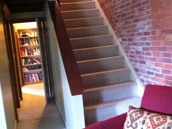 Stairs leading to loft with extensive exposed brick and exp