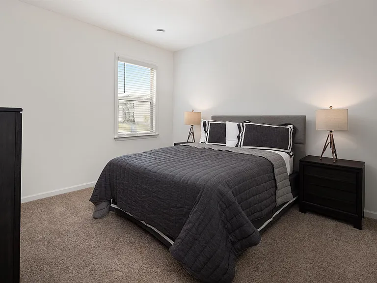 The third bedroom with queen size bed and large window letting in a ton of natural light.