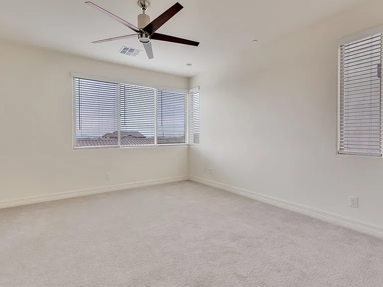 Large master bedroom with new fan with light and white horizontal blinds with great views out of the windows of the mountains.
