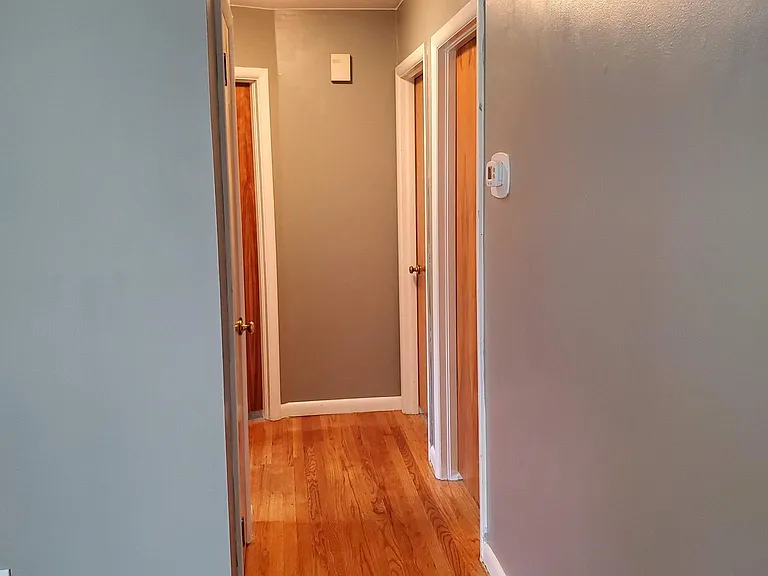 Hallway leading to three bedrooms and bathroom.