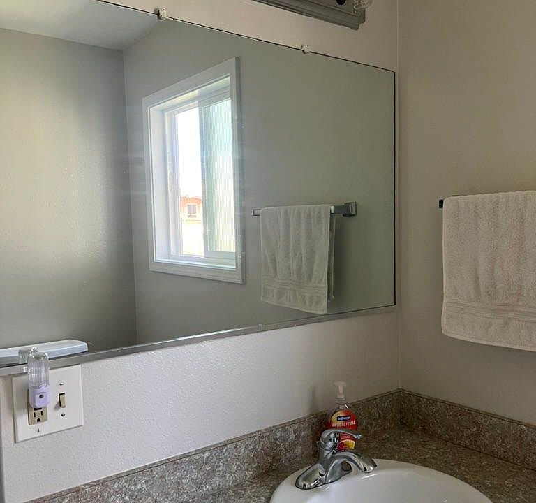 Vanity and toilet in one area of the bathroom, tub and extra linen storage in the room next to it. (Extra large bathroom)