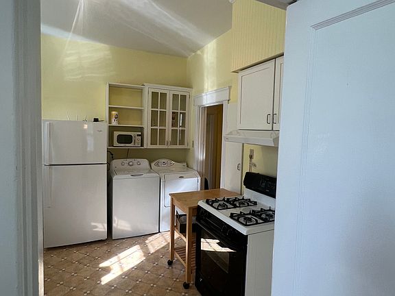 kitchen. gas stove , washer and dryer next to refrigerator, lots of shelves and cabinets
