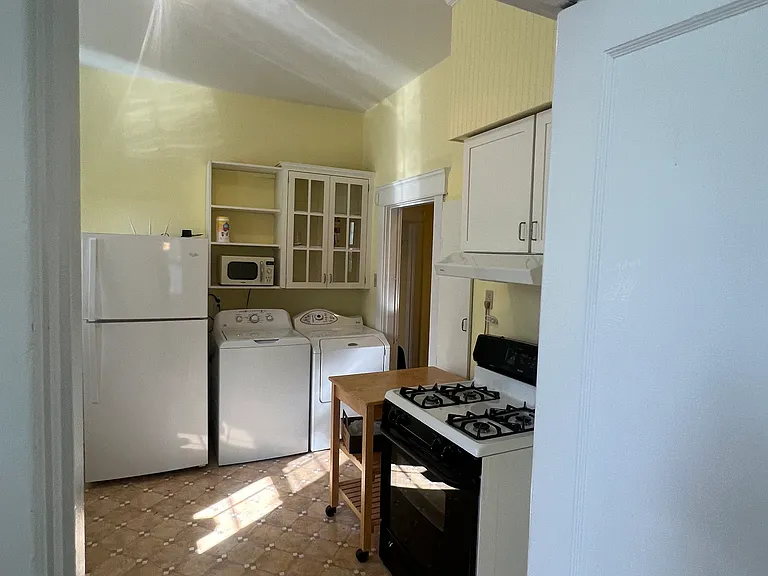 kitchen. gas stove , washer and dryer next to refrigerator, lots of shelves and cabinets