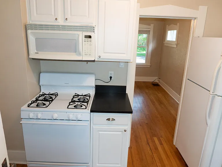 Kitchen has newer gas range with overhead microwave.