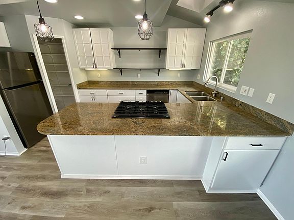 Large Kitchen with plenty of countertop space, new Samsung Gas Cooktop and Oven, newly painted cabinets, lights, walk-in pantry and floating shelves.